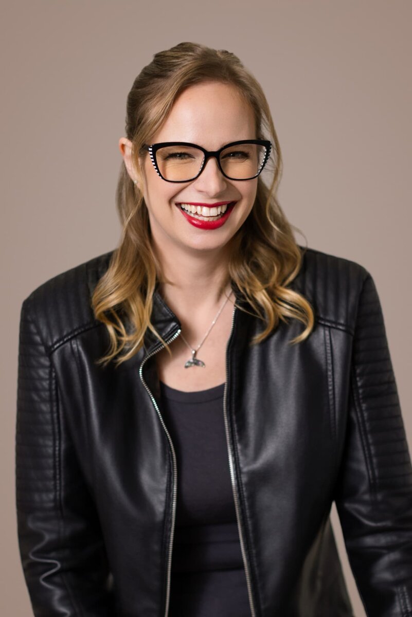 Cammy De — standing portrait, navy blazer